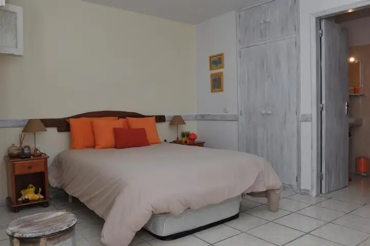 Studio with a double bed and orange cushions