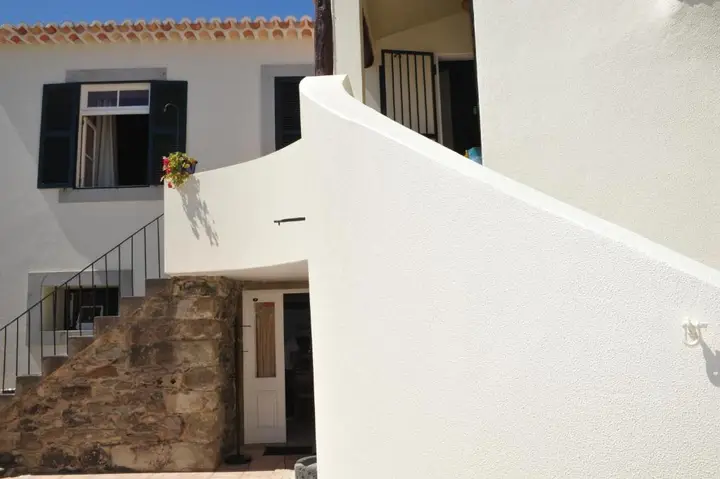 Stone steps to the upper floor, with green shutters